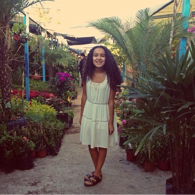Elisa Carranza, freshman, poses for a photo in an indoor garden. Submitted Photo