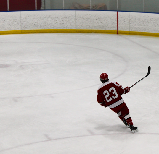 Adam Hobbs, senior and team captain, skates across the ice during an away game against Brookfield. The team won the game with a score of 5-3. “Being captain this year is really an honor, but being captain for such a good group of guys makes it even better,” Hobbs said. 
