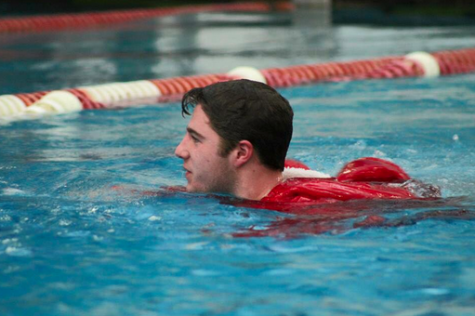 Callahan swims toward his teammates after jumping into the water with his parka on senior night.