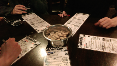 A group of friends fill out their menus as they enjoy complementary peanuts.