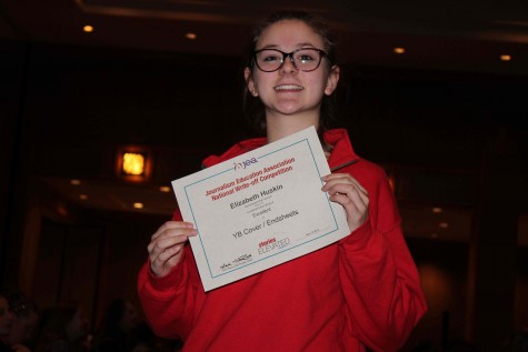Elizabeth Huskin, junior, poses with her certificate after winning Excellent in the category of yearbook cover/endsheets. Huskin designed a yearbook cover along with endsheets before Highlander Publications traveled to Denver, CO. “I was very surprised when I won and I am super proud of my work,” Huskin said.