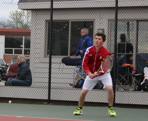 Eric Mullins, sophomore,  playing No. 1 singles winds up for a backhand during warm-up.