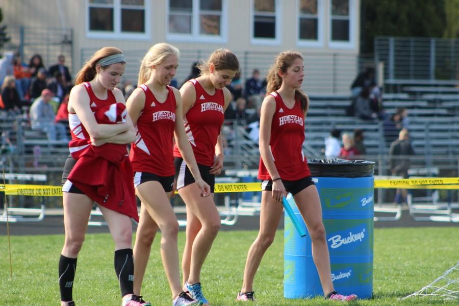 Katie Wegmann, sophomore, Maddie Powell, junior, Anna Keller, junior and Allie Levin, sophomore, walk  to cool off after their race. 