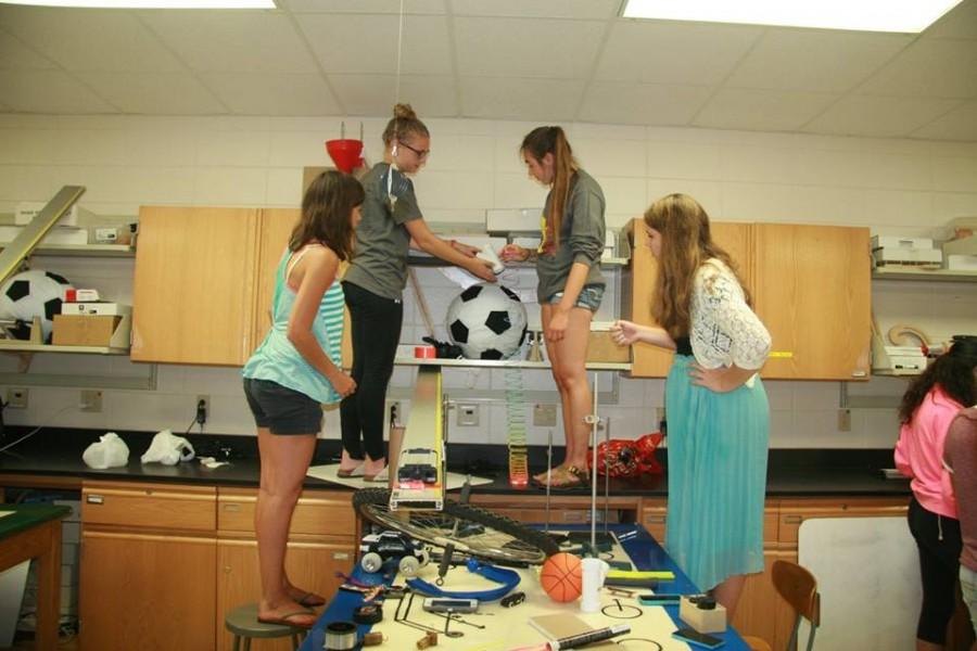 Sophie Smith, Lexi Emond and Megan Ochalek, seniors, and Emily Boehlke, junior, work on their Rube Goldberg machine on Saturday night. The team worked together at last years competition. Smith said, “It was a lot of fun to work together. It was hard, but it was worth it.”