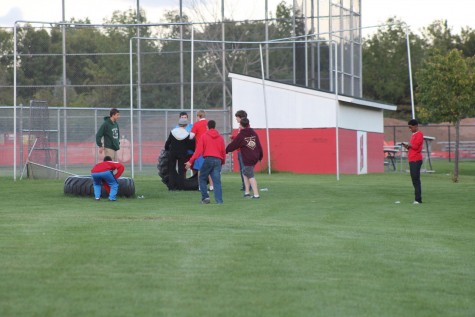 Students goof around with tires on the baseball diamond after the tailgate.