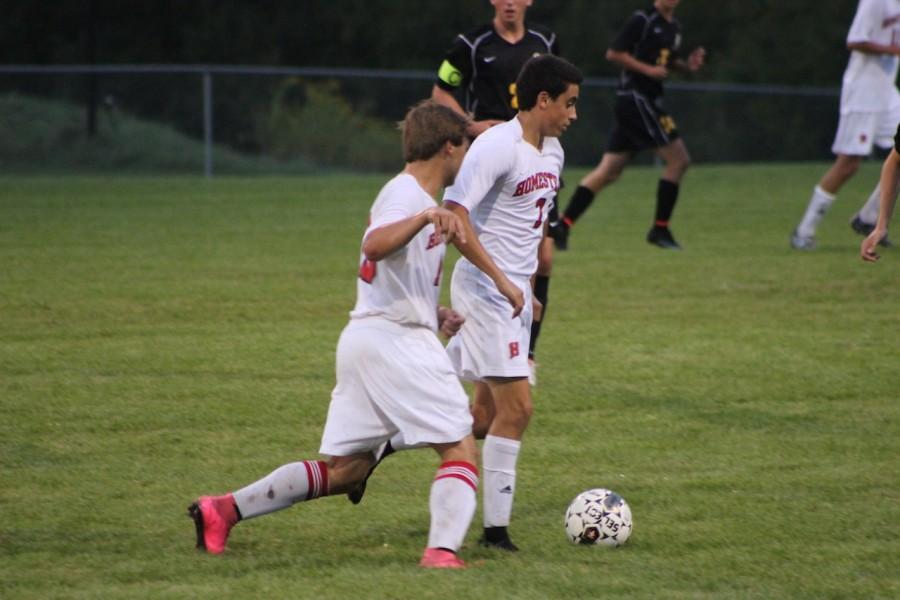 Number 7 Josh Cooley, senior, and number 18, Jacob Bartscher, senior, drive to ball down the field.