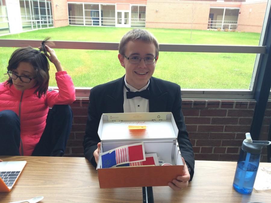 Mitchell Larson, junior and AP French student, sells bookmarks during A Lunch. Larson went from table to table in his tuxedo explaining the fundraiser and collecting donations.