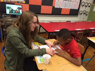 Alex Reynolds, sophomore, helps a student do his homework. Kids 4 Kids was founded in 2013 with the goal of helping Milwaukee public school students. 
