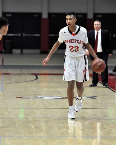 Foster dribbles the ball towards the hoop.