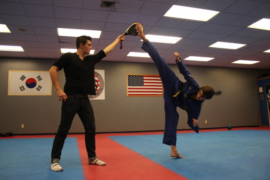 Alex Babiasz kicks the paddle as he shows off his flexibility and his kicking height.