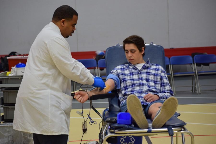 Doug Lennon, senior, looks on while the nurse prepares to take his blood in last years blood drive. “Though it hurts a little, giving blood is all worth it in the end,” Lennon said. 