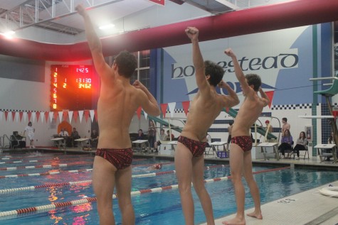James Guskov, junior, Patrick Norman, senior, and Michael Ball, senior, lead the rest of the junior varsity and varsity boys swimmers in their chants. 
