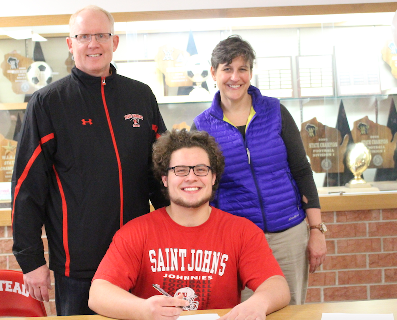 Chris Malicky, senior, poses with family on national signing day. 