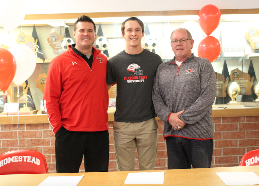 Coaches Matthew Wolf and Dave Keel accompany St. Cloud State University football commit Jake Bruner, senior, on national signing day. 