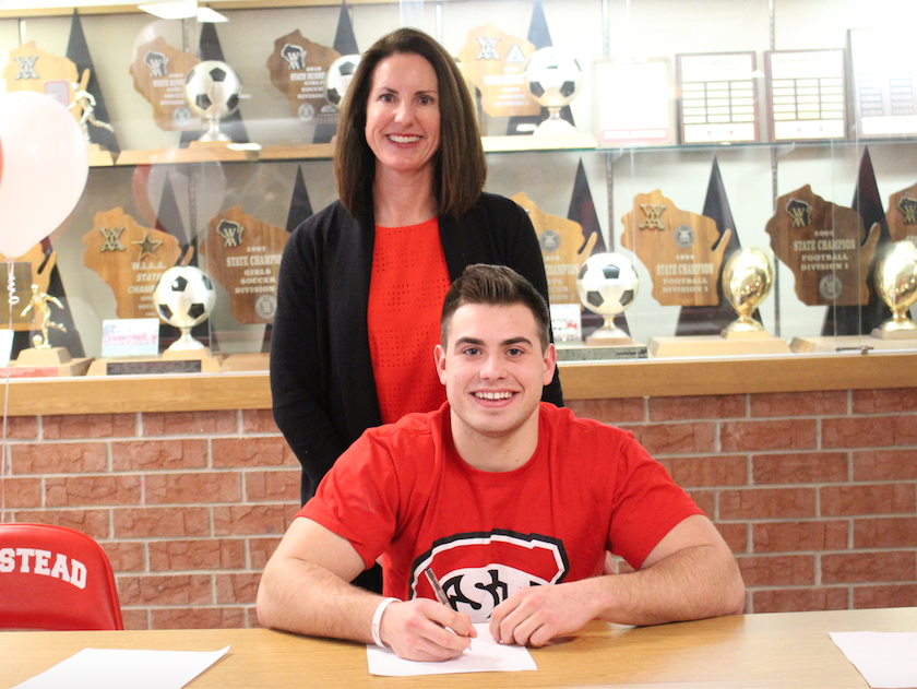 Matthew Winters, senior, supported by mother Ann Winters pose on national signing day where Matthew has committed to play Division II football at St. Cloud State University.