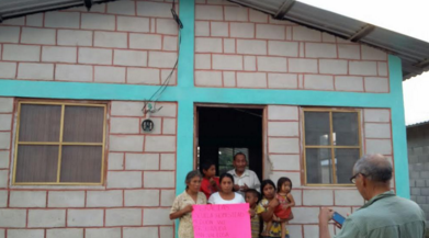 A Honduran family stands in front of the home the Spanish Club fundraiser built and furnished for the them.