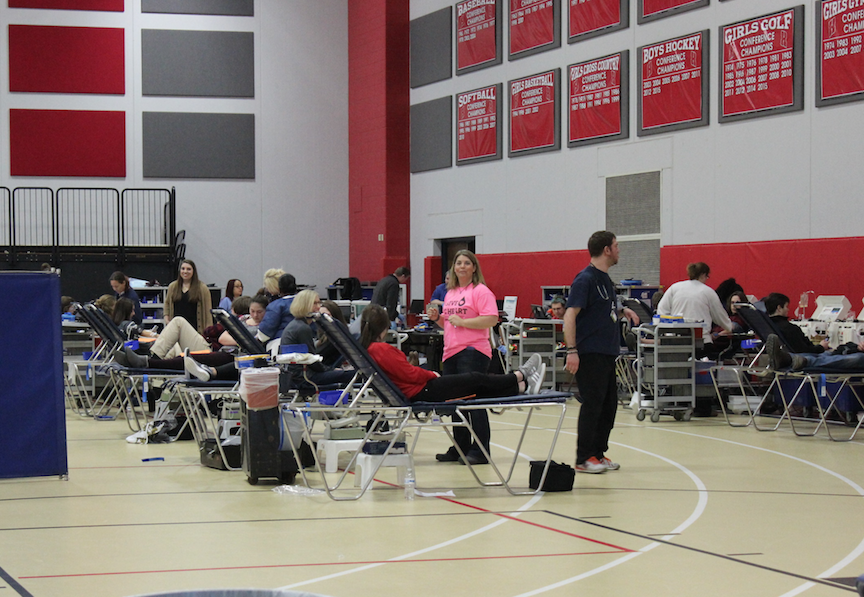 The field house is set up as a blood bank filled with students and teachers donating blood. 