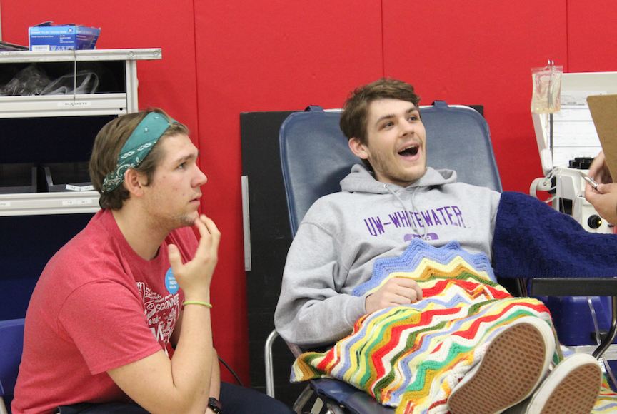 Mitch Lauenstein and Michael Matthews, seniors learn about the blood taking process from a nurse. 