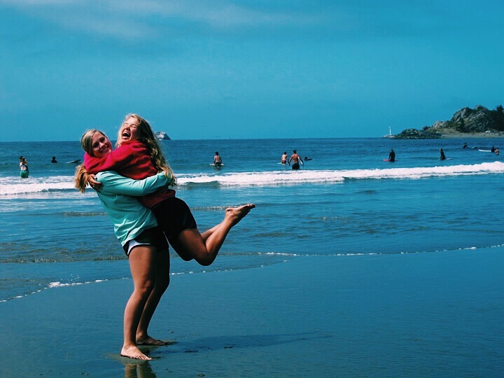 Molly Plamann, freshman, and a friend hug on the beach.