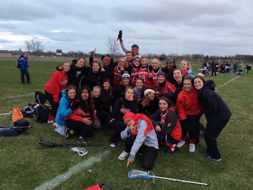 The Homestead girls lacrosse team celebrates after its inaugural game.