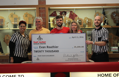 Evan Routhier, senior, poses with his parents and Foot Locker employees. 