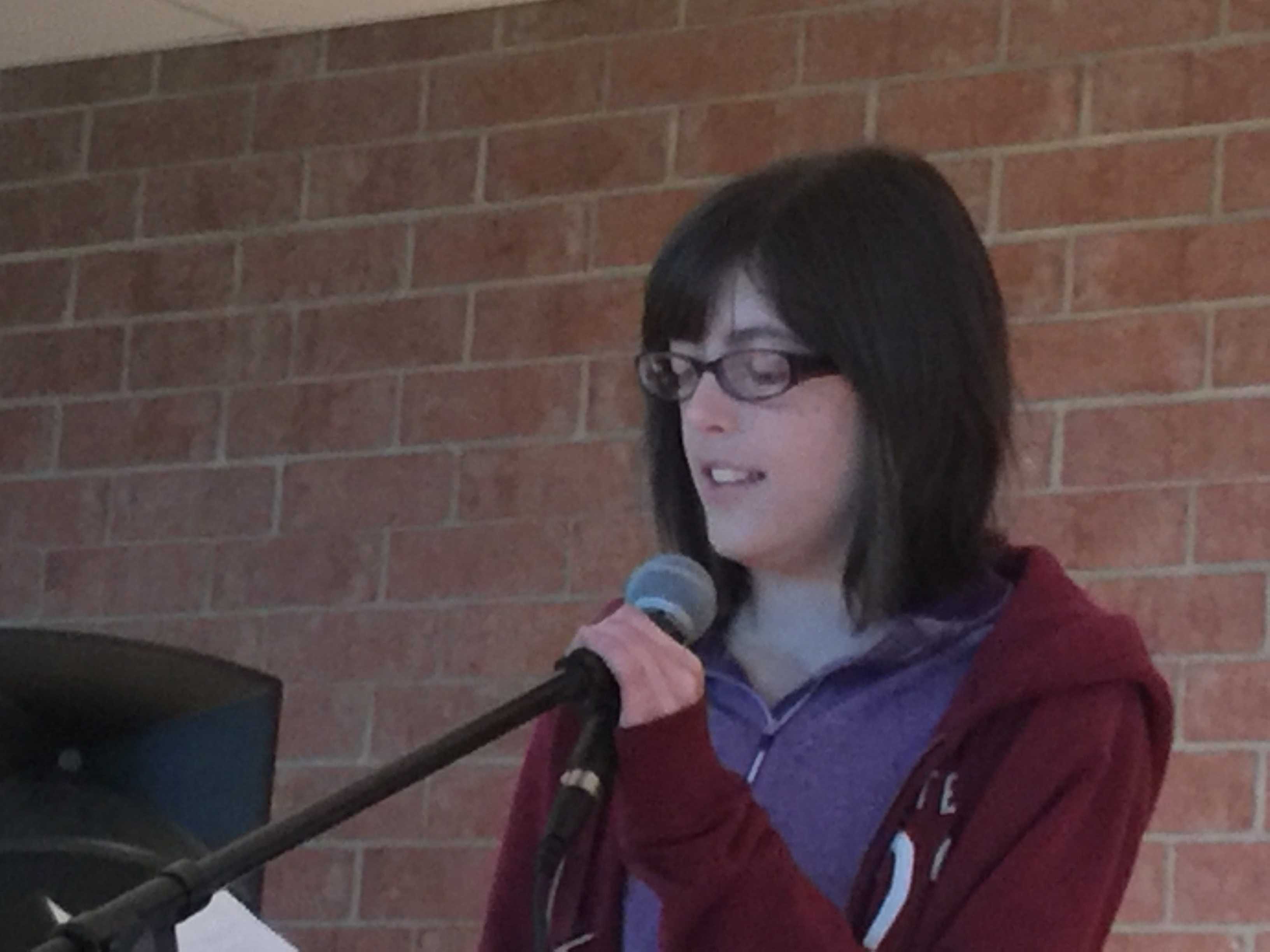 Hannah Bentley, sophomore, presents her poem "And the Giraffes Are Eaten Alive" at HHS Unplugged. Bentley wrote the poem in her bedroom a couple of days before the event occurred. "I was really nervous, but it was nice to be able to perform my piece," Bentley stated. 