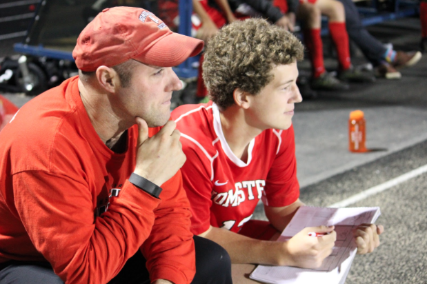 Collin Reiels, senior, sits alongside Coach Tony Navarre at the boys soccer game on Friday. 