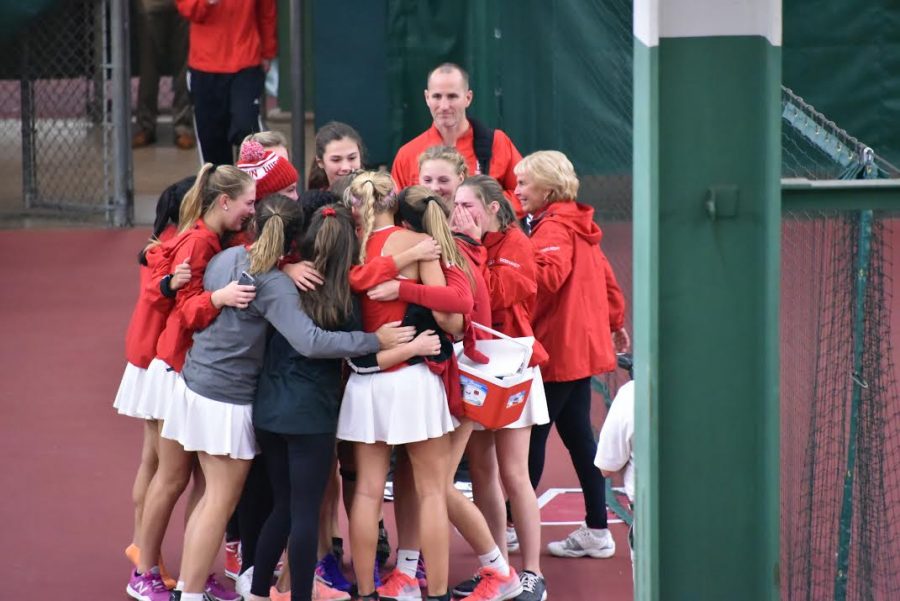 The girls varsity tennis team hug after winning state. The girls were undefeated throughout their entire season. I couldnt have been more happy to have won state with my teammates, Helen Watkins, junior, said. 
