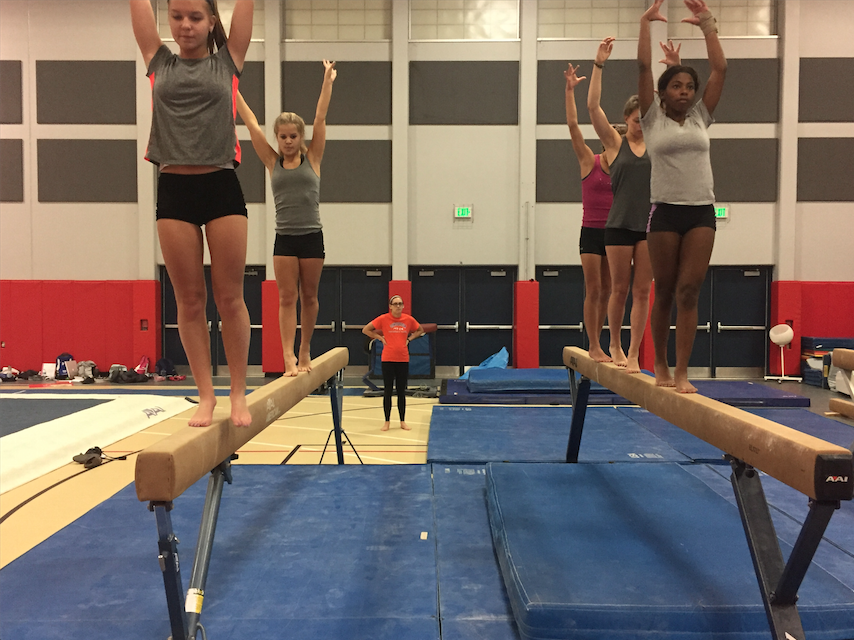 Tristi March, girls gymnastics coach, teaches beam drills. The entire team has been looking forward to the new coaches. The coaches are super fun and they have big plans for the season. I am excited to see what they all have planned, Natalie Ceelen, junior, said.