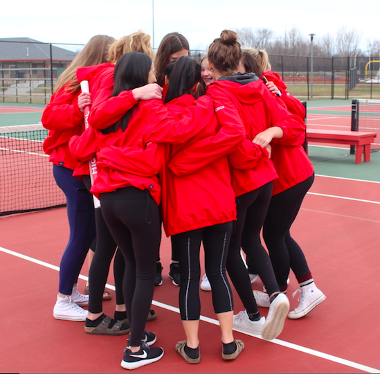 The girls huddle while performing their team cheer.