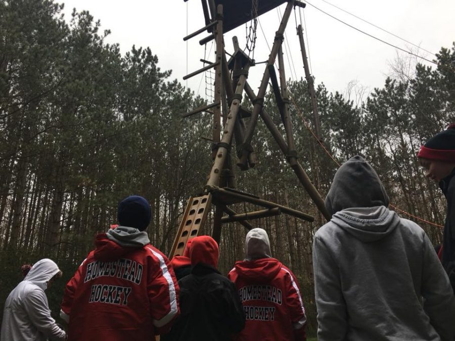 The Homestead hockey players watch their teammates battle through the arctic climb ropes course. 