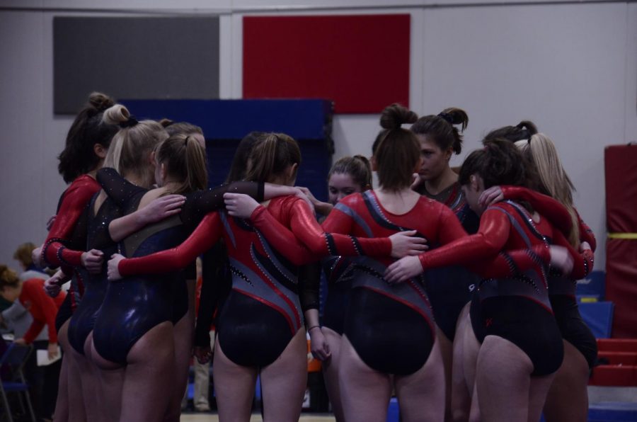 The team huddles and chants their cheer before beginning the meet.