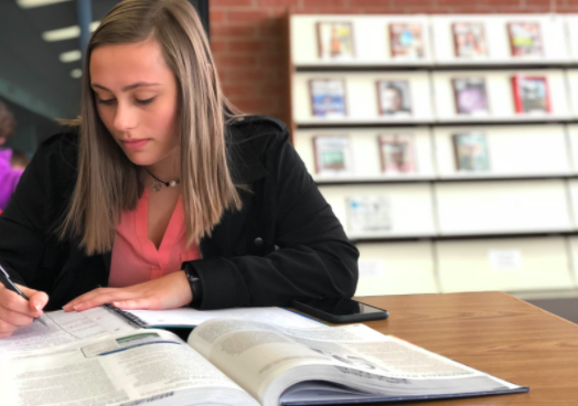 Rachel Sandlow, senior, uses her extra 20 minutes of study hall to complete a homework assignment. 

