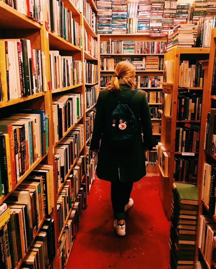 Como strolls through the aisles of the library, receiving inspiration for her own writing.