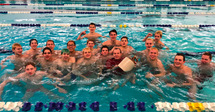 Homestead’s varsity swim team celebrates their win against West Bend with the Homestead Jug, multicolored hair included. 