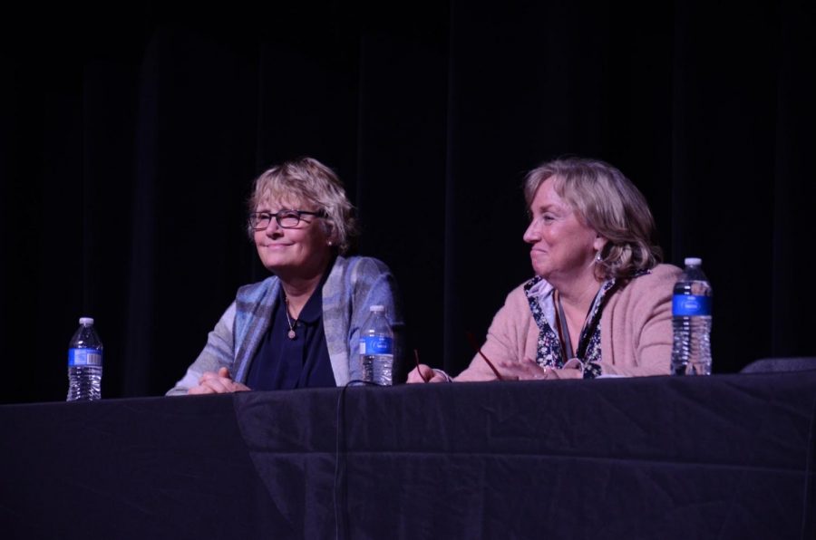 Dr. Charlene Gaebler (left) and Sue Martin (right) observe another speaker. 