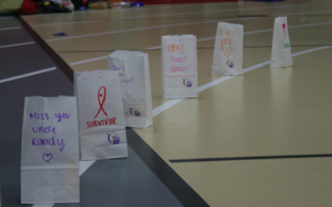 Students decorate paper bags to set around the fieldhouse for the luminaria ceremony. 