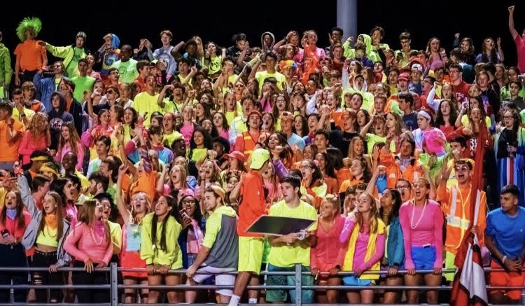 The student section  pulses with energy as they cheer on the varsity football game on Friday, Sept. 13. Every week, the student section leaders decide on a new theme, choosing neon for the Sept. 13 game. My favorite theme has been neon! Even though it was hard to find clothes, it was still really fun to dress up in bright colors with my friends, Caroline Downey, junior, said.  