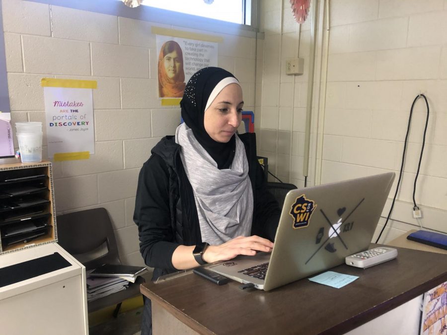 Ms. Manal Roumani works at her desk as a computer science teacher. 