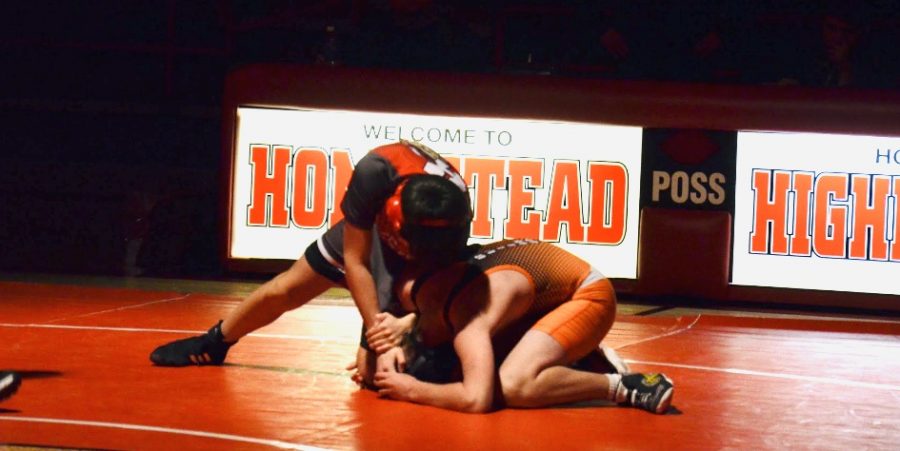 Cole Movessian, sophomore, pins his opponent to finish his match for a Highlander win.