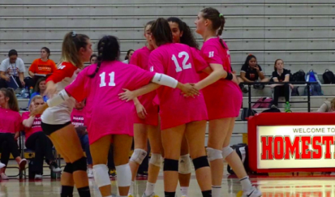 Members of the Homestead High School girls volleyball team huddle together in between plays. 