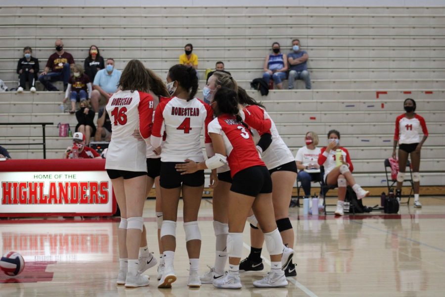 The girls volleyball team celebrates together after scoring a point in their first home game.