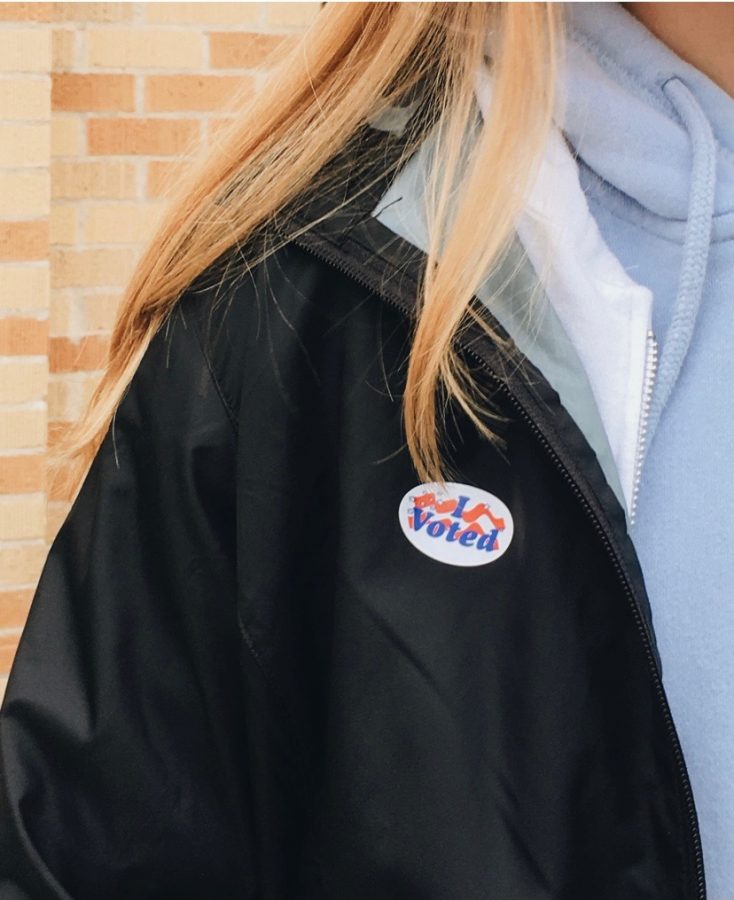 Paige Wallner, senior, shows off her sticker after she voted on Oct. 20.