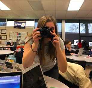 Hannah Kennedy, senior, takes a photo in her journalism class.