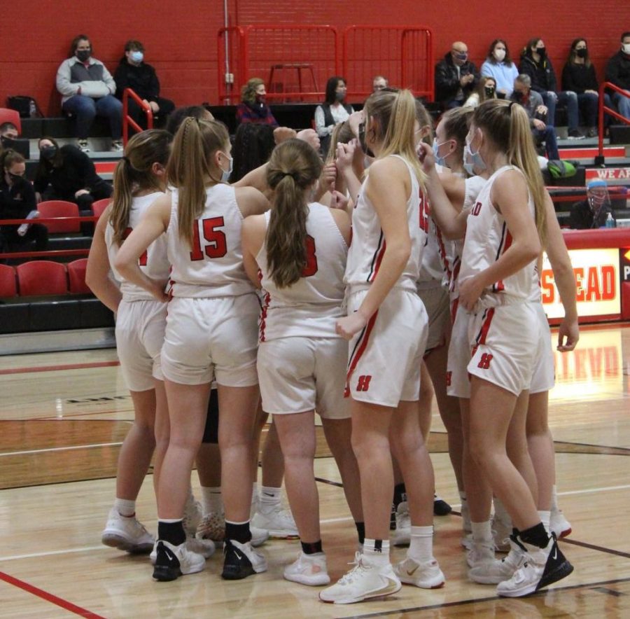 The girls basketball team huddles together during their game on Friday night.