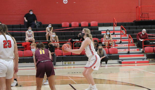 Senior Lexi Buzzell steps up to the line for a shooting foul against West Bend East while her team sits (socially distanced) behind her.
