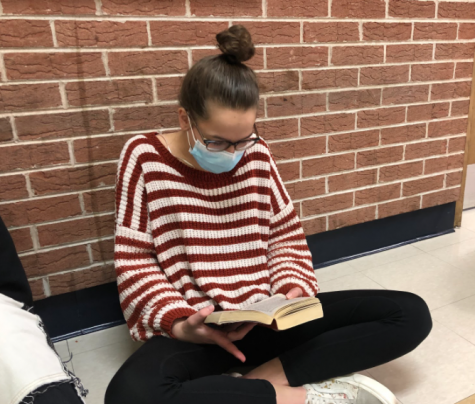 Luedtke participates in reading time in the hallway outside her class.