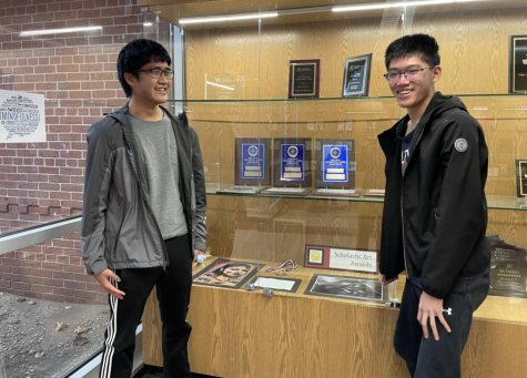 Seniors Ethan Wang (left) and Eric Wan (right) pose in front of Homestead’s Mathematics League Championship trophies. 