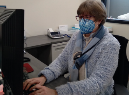 Linda Dean, administrative assistant, works behind her computer where she shared information with the school. 