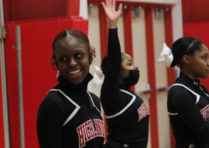Semaj Harris and her team cheer on the varsity boy basketball team at their game against Nicolet.